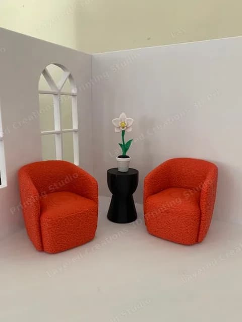Miniature lounge concept with two orange armchairs, side table and orchid