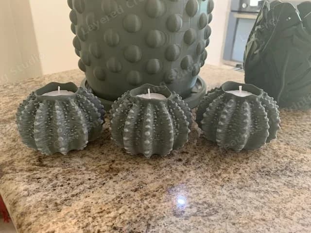 The set of three dry-brushed sea urchin tea light holders with tea lights